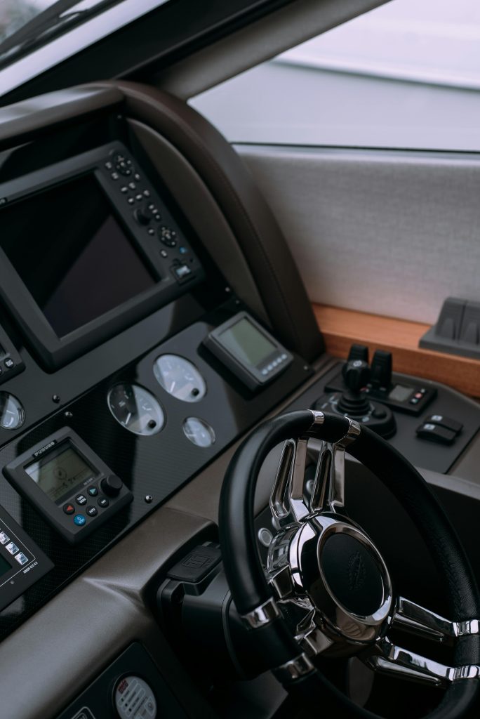 Close-up of a sleek control panel with steering wheel and technology interface in a luxury vehicle.